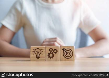 dartboard above Gear and Lightbulb icon block on desk. business planning process, goal, strategy, target, mission, action, objective, teamwork and idea concept