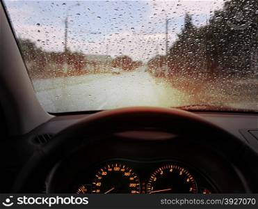 dashboard and rain droplets on car windshield