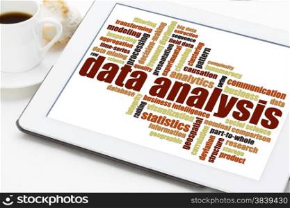 data analysis word cloud on a digital tablet with a cup of coffee