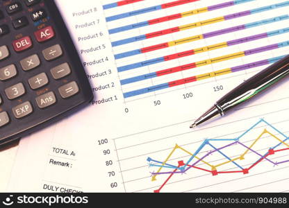 Data analyzing with calculator and pen. from charts and graph to find out the result.