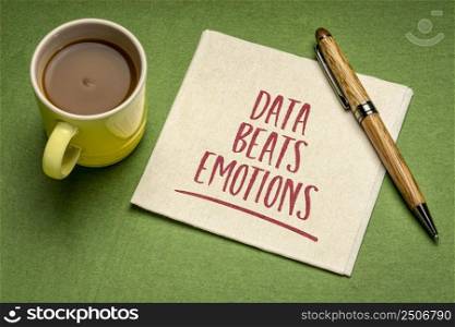 data beats emotion reminder, handwriting on a napkin with a cup of coffee, facts, research, science and analytics concept