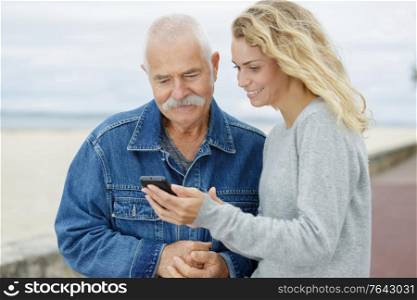daughter and dad using smartphone