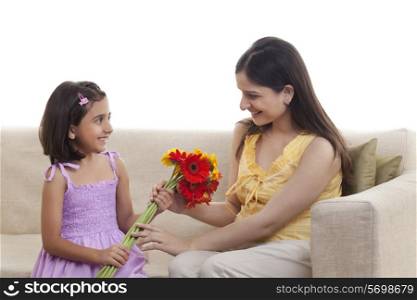 Daughter giving flowers to pregnant mother