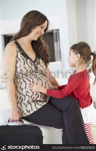Daughter Greeting Pregnant Mother Home From Work