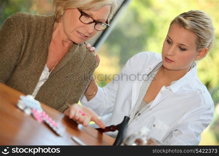 Daughter helping mother take medication