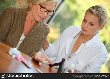 Daughter helping mother take medication