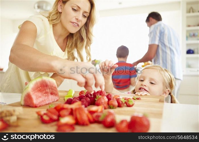 Daughter Helping Mother To Prepare Family Breakfast
