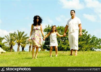 Daughter holding hands of her parents on natural background