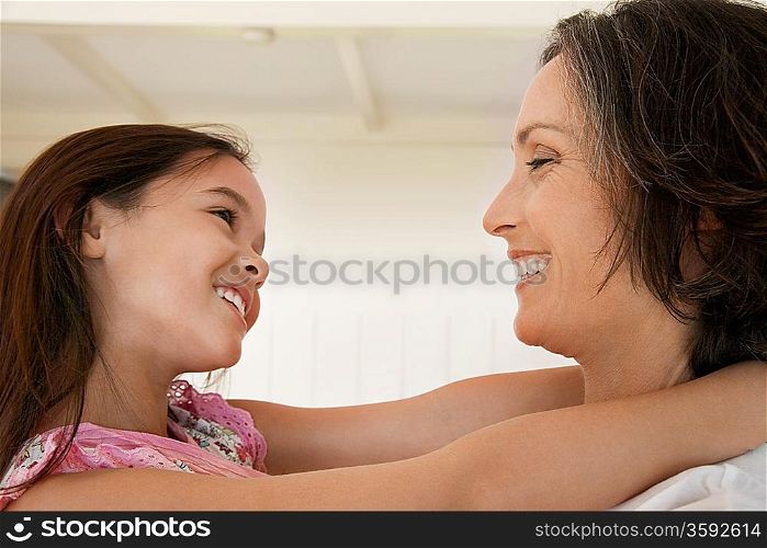 Daughter hugging mother head and shoulders side view
