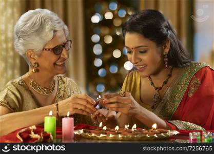 Daughter in law decorating the house with mother in law on the occasion of diwali