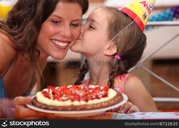 Daughter kissing mommy at birthday party