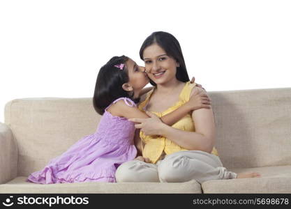 Daughter kissing pregnant mother