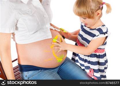 Daughter painting mother&acute;s pregnant belly and smiling isolated on white