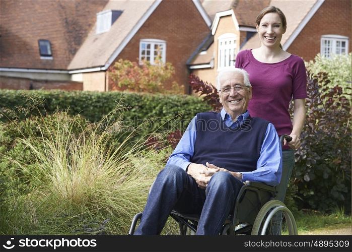 Daughter Pushing Senior Father In Wheelchair