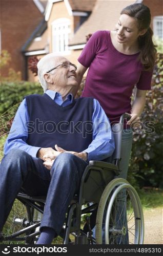 Daughter Pushing Senior Father In Wheelchair