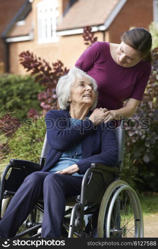 Daughter Pushing Senior Mother In Wheelchair