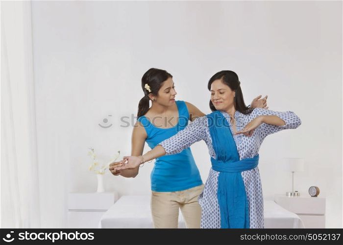 Daughter teaching mother to dance