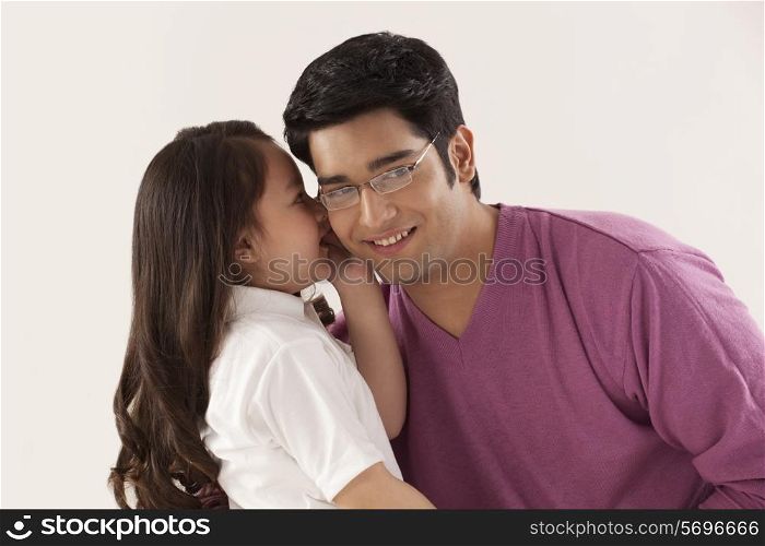 Daughter whispering in father&rsquo;s ear