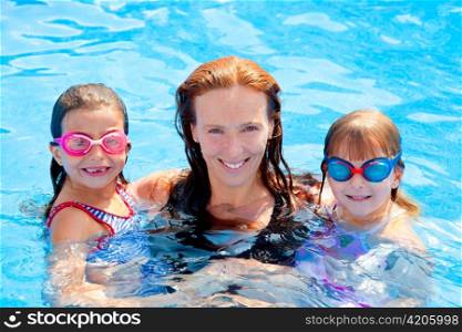 daughters and mother family swimming in pool on summer vacation
