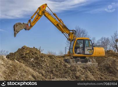 day view of yellow excavator with shovel in action at construction site