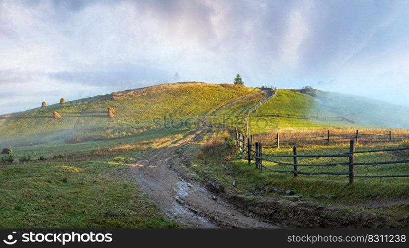 Daybreak haze clouds on hill top and dirty road   Carpathian mountain, Ukraine 