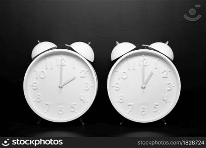 Daylight saving time concept. Two White Retro clock isolated on black background. Copy space