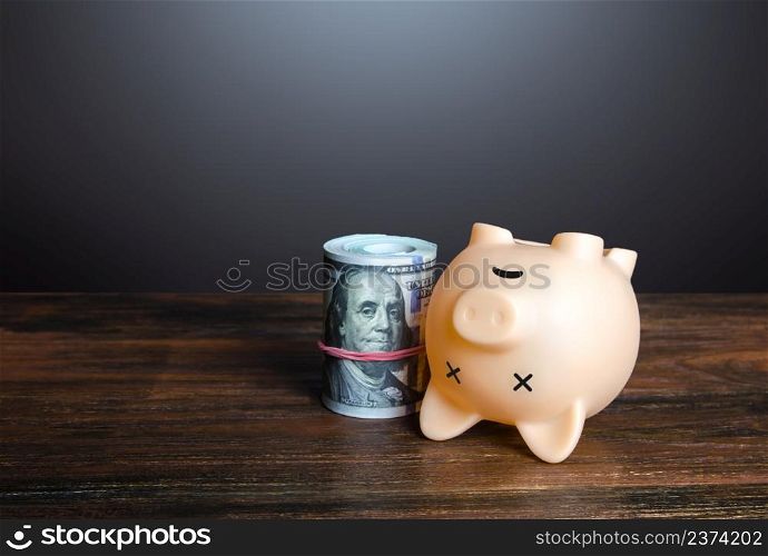 Dead pig piggy bank with money. Financial crisis, depletion of savings and bankruptcy. Default, non-payment of obligations. Devaluation, inflation. Impoverishment. Refinancing restructuring of debts
