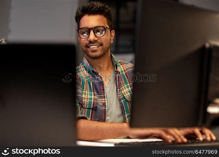 deadline, technology and people concept - close up of creative man in glasses working at night office and thinking. close up of creative man working at night office. close up of creative man working at night office