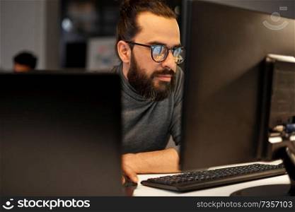 deadline, technology and people concept - close up of creative man in glasses working at night office and thinking. close up of creative man working at night office