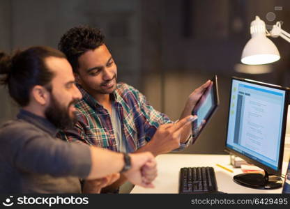 deadline, technology and people concept - creative team with tablet pc computer and smartwatch working together late at night office. creative team with tablet pc working at office