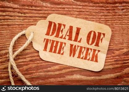 deal of the week sign a paper price tag against rustic red painted barn wood