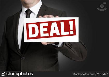 Deal sign is held by businessman.. Deal sign is held by businessman
