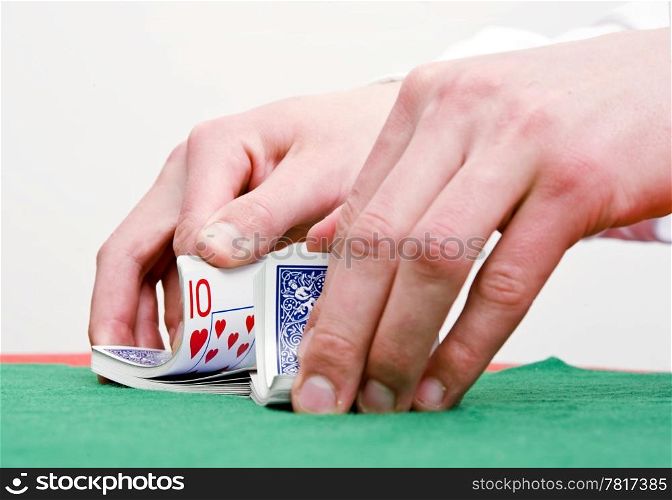 Dealer&rsquo;s hands shuffling cards during a poker game