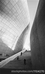 DEC 11, 2015 Seoul, South Korea - Dongdaemun design plaza or DDP modern free from building architecture in black and white with metalic facade and long entrance stair by Zaha Hadid