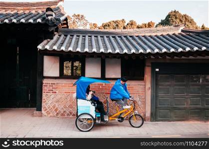 DEC 13, 2016 Seoul, South Korea - Tourists and Pedicap rickshaw tour in beautiful vintage Bukchon Hanok old local village.