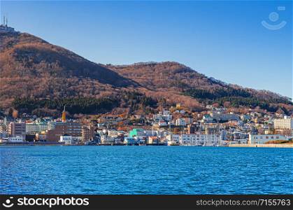DEC 2, 2018 Hakodate, JAPAN -Hakodate blue harbour bay and Motomachi cityscape buildings with mount hakodate view and blue sky in winter