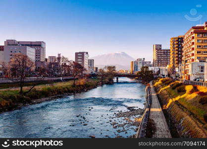 DEC 2, 2018 Iwate, Japan - Mount Iwate Morioka city scene with buildings and promenade at Katakami river with warm sunset light clear sky in winter - Tohoku region beautiful landscape