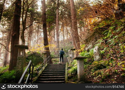 DEC 3, 2018 Yamagata, Japan - Tourist on Yonsunmichi path in pine forest with evening light at Yamadera Risshaku ji temple in autumn.