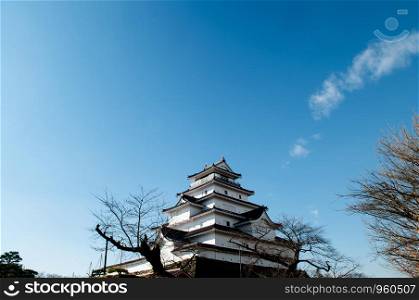 DEC 4, 2018 Aizu Wakamatsu, JAPAN - Aizu Wakamatsu Tsuruga Castle and tree under winter blue sky. Fukushima Samurai lord fortess in Edo period