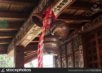 DEC 4, 2018 Aizu Wakamatsu, JAPAN - Old rusty antique Japanese bronze shinto bell or Suzu with rope hanging from wooden ceiling in Shrine at Tsuruga Jo castle