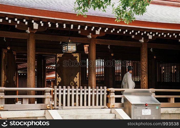 DEC 5, 2018 Tokyo, Japan - Kannushi or Shinshoku Shinto priest of Meiji Jingu Shrine in white cloth at corridor of main hall - Most important historic shrine dedicated to Emperor Meiji and his Empress