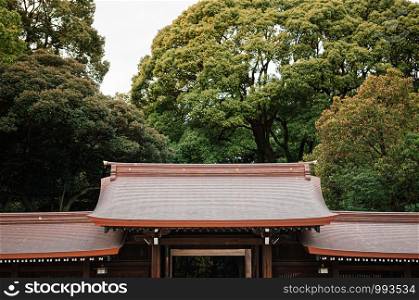 DEC 5, 2018 Tokyo, Japan - Meiji Jingu Shrine Historic Wooden gate and corridor with big trees in background - Most important shrine of Japan capital city.
