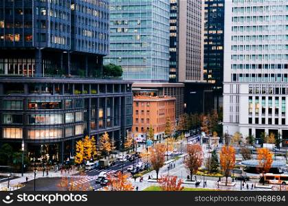 DEC 6, 2019 Tokyo, Japan - Daimyo - Koji Avenue Marunouchi District Tokyo downtown in Autumn with many people at pedestrains crosswalk and Tokyo station square from high angle