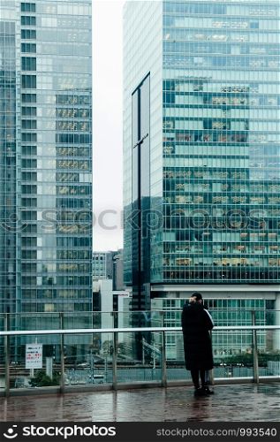 DEC 6, 2019 Tokyo, JAPAN - Marunouchi District modern office buildings tourist enjoys Tokyo downtown cityscape in evening. View from Kitte building observatory deck.