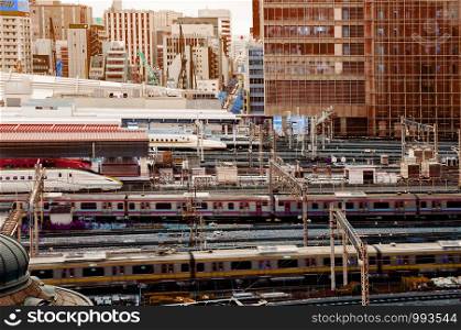 DEC 6, 2019 Tokyo, Japan - Tokyo Station JR train in motion and Shinkansen tracks from aerial view. Train traffic at Tokyo station in evening with city center background