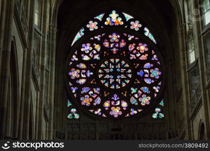 Decal window transparency of rosette inside the cathedral of St Vitus in Prague, a church with dark Gothic towers guarded by gargoyle: the main religious symbol of the Czech Republic