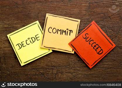 Decide, commit, succeed motivational word abstract on colorful sticky notes against rustic wood