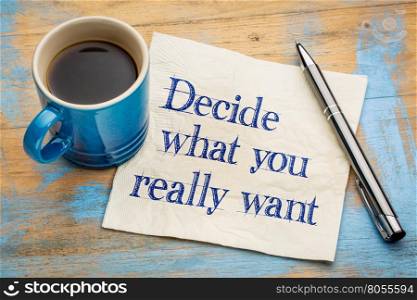 Decide what you really want - handwriting on a napkin with a cup of espresso coffee