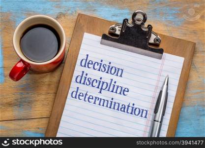 Decision, discipline, and determination words on a clipboard with a cup of coffee - motivational tips for achieving goals and success