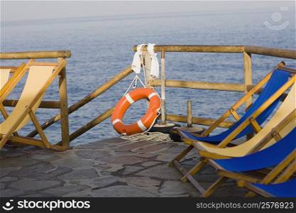 Deck chairs and a life belt on a pier, Capri, Campania, Italy